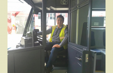 Shaun in the driver's seat of a bus